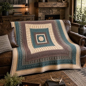 May include: A square crochet blanket featuring concentric geometric patterns in shades of cream, teal, and brown. The design includes a central circle surrounded by alternating textured stitches, intricate lace-like borders, and solid color bands.
