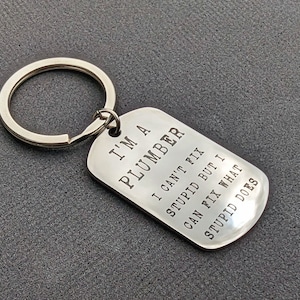 Soy fontanero, no puedo arreglar estupideces, pero puedo arreglar lo que hace la estupidez - Llavero de acero inoxidable con fuente con efecto estampado personalizado