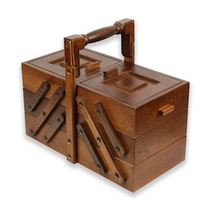 Könnte beinhalten: Eine Nähbox aus Holz mit einem Klappdeckel und einem Griff. Die Box hat mehrere Fächer und ist aus dunkelbraunem Holz.