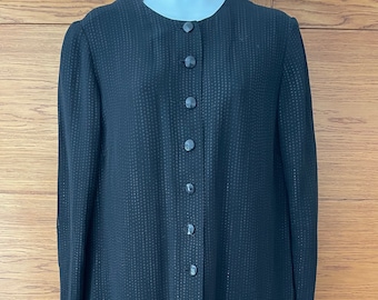 May include: A black long-sleeved jacket with a button-up front and a subtle dotted pattern.