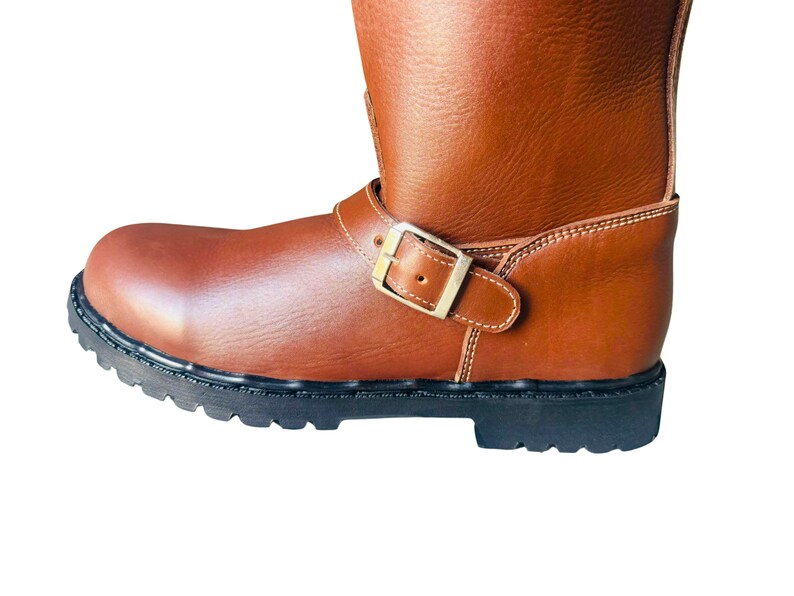 May include: Brown leather motorcycle boots with a buckle closure and a black rubber sole.