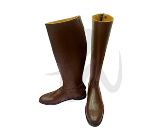 May include: A pair of brown leather riding boots. The boots are knee-high with a smooth finish. One boot is angled, and the other is straight, showing a zipper and a yellow interior.