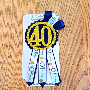 May include: A navy blue and gold 40th birthday ribbon. The center features a gold glitter "40" on a navy blue scalloped circle. Navy blue ribbons with "Happy 40th" text and balloon graphics hang below. The words "Handmade by Crazzietem" are printed on the card.