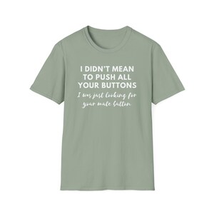 May include: A sage green t-shirt with the text "I didn't mean to push all your buttons. I was just looking for your mute button."