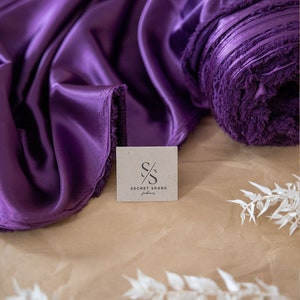 May include: A roll of purple satin fabric with a tag that says "SECRET SPARK fabrics".