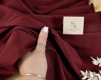 Tela de sarga mate Mikado color vino, lujosa mezcla de satén mate con caída estructurada para confeccionar vestidos de novia, chaquetas y ropa formal.