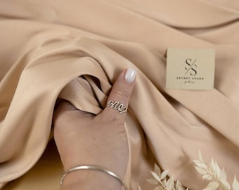 Satén elástico mikado beige místico, calidad de diseñador premium, caída mate estructurada, sarga de peso medio para novias y trajes formales.