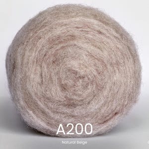 Op de afbeelding: Een bol natuurlijk beige gekaarde wol, gelabeld als A200. De wol is strak opgerold en vertoont een zacht, getextureerd oppervlak. Het product is van Anna Felt.