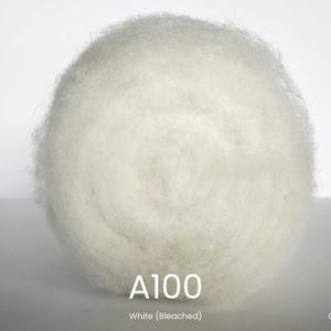 Op de afbeelding: Een close-up van een grote, ronde bal van witte, gebleekte gekaarde wol. De tekst "A100 White (Bleached)" staat eronder. De merknaam "ANNA FELT" staat linksonder en "Gekaarde wol" rechtsonder. Ideaal voor viltprojecten.