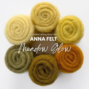 Op de afbeelding: Een set van zes gekaarde viltwolrollen gerangschikt in een cirkelvormig patroon, met tinten crème, geel, olijfgroen en oranje. De tekst Carded Felting Wool Set ANNA FELT Meadow Glow staat in het midden van de wolrangschikking.