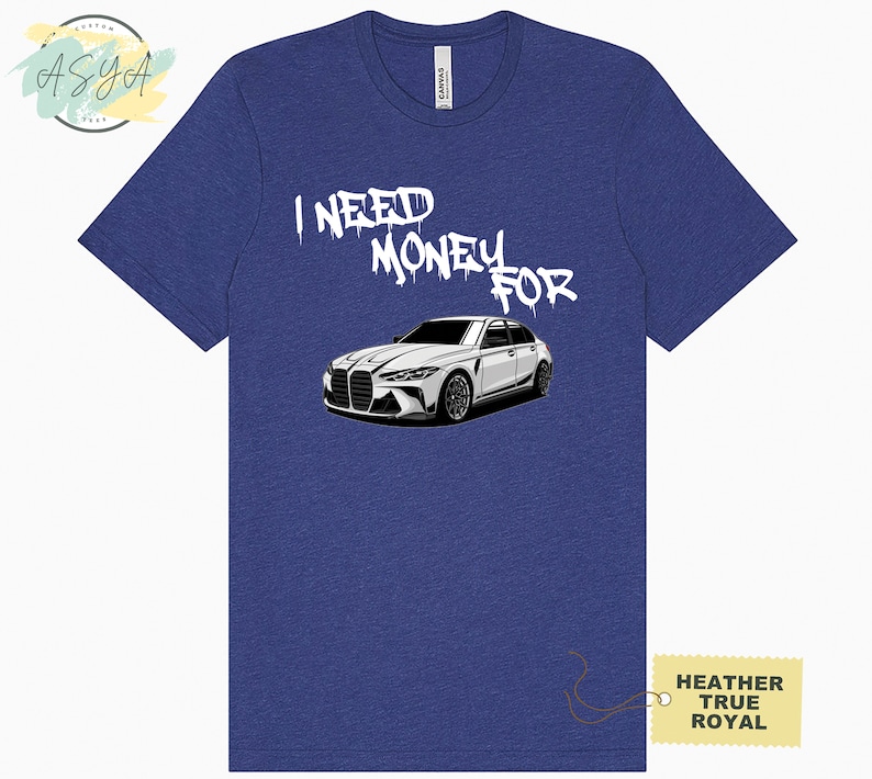 May include: A blue heather t-shirt with the text "I NEED MONEY FOR" in white spray paint lettering. A white car is pictured below the text. The text "HEATHER TRUE ROYAL" is on a yellow tag in the bottom right corner.
