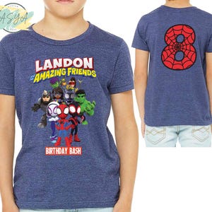 Pode incluir: Camiseta azul com um gr&aacute;fico de super-her&oacute;is de desenhos animados e o texto "Landon and the Amazing Friends Birthday Bash".