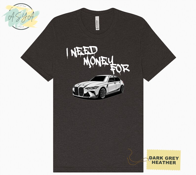 May include: Dark grey heather t-shirt with a white car and the text "I need money for" in white spray paint font.
