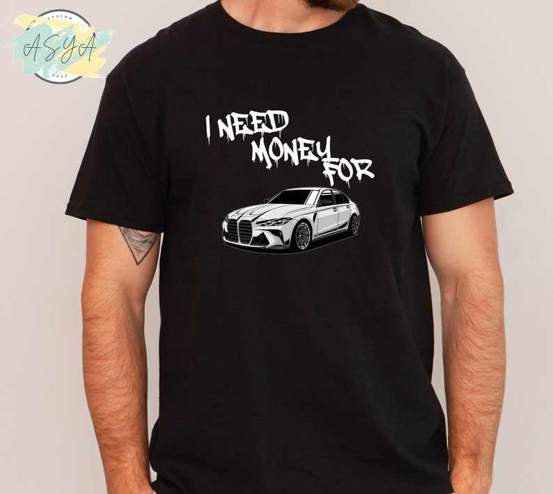 May include: Black t-shirt with white text that reads "I NEED MONEY FOR" and a white illustration of a car.