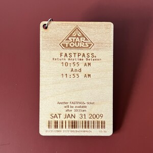 May include: A wooden Star Tours FastPass ticket with a return time between 10:55 AM and 11:55 AM on Saturday, January 31, 2009. The ticket has a barcode and the text "Another FASTPASS. ticket will be available after 10:55am".