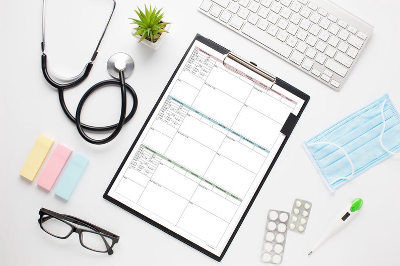 May include: A medical workspace with a stethoscope, clipboard, keyboard, face mask, and thermometer. Also included are eyeglasses, sticky notes, a small plant, and medication. The items are arranged on a white surface.