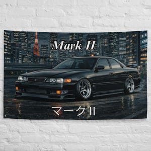 Könnte beinhalten: Schwarzes Mark II Auto-Wandteppich mit dem Text "Mark II" in englischen und japanischen Schriftzeichen. Das Auto ist vor einer nächtlichen Stadtlandschaft geparkt. Der Hintergrund zeigt hohe Gebäude und Stadtlichter.