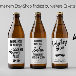 May include: Three brown beer bottles with white labels and gold caps. The labels have black text, including phrases like "coolest dad" and "Father's Day beer." The bottles are arranged against a light gray background.