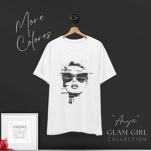 May include: White t-shirt featuring a black and white graphic of a woman wearing sunglasses. The text "Anya" and "GLAM GIRL COLLECTION" is printed below the graphic.