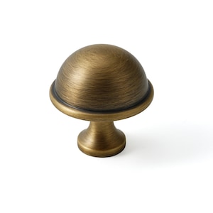 May include: A brushed antique brass cabinet knob with a dome-shaped top and a round base.