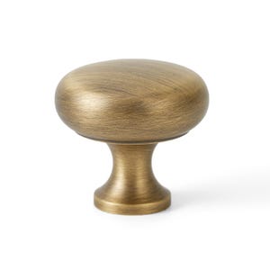 May include: A brushed brass cabinet knob with a round top and a short, round base.
