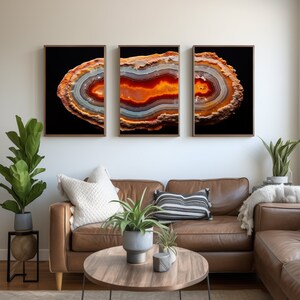 May include: Three framed prints of a slice of agate with orange, red, and white banding against a black background.