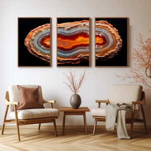 May include: Three framed prints of a colourful agate slice with orange, red, white, and grey bands against a black background.