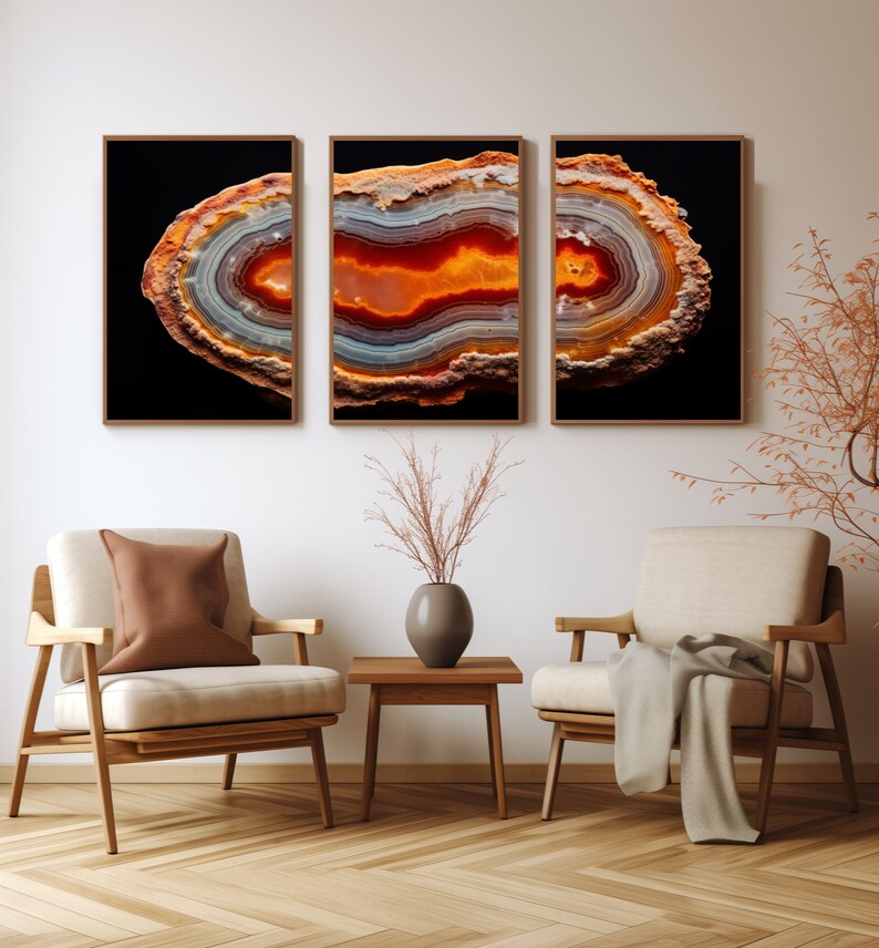 May include: Three framed prints of a colourful agate slice with orange, red, white, and grey bands against a black background.