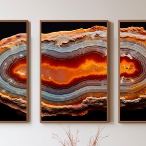 May include: A close-up of a tri-panel wall art print featuring a colourful agate slice with orange, red, and white bands. The agate is set against a black background.