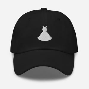 May include: Black baseball cap with a white embroidered design of a dress. The cap has a curved brim and a structured crown. The dress design is centered on the front of the cap.