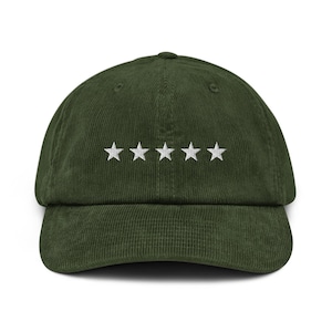 May include: A dark green corduroy baseball cap with a curved brim. The cap features five white embroidered stars across the front. The hat is a classic style, suitable for casual wear.