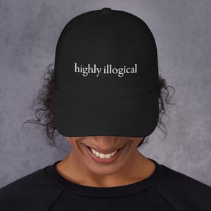 May include: Black baseball cap with white embroidered text that reads "highly illogical".