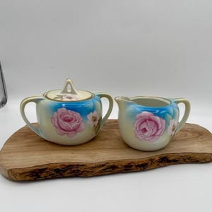 May include: A set of three ceramic mugs with a speckled, matte finish in cream, light grey, and dark grey. Each mug has a simple, minimalist design, ideal for coffee or tea.