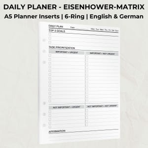 Peut inclure: Feuilles de recharge de planificateur A5 blanches avec une conception à 6 anneaux. Le planificateur comprend une mise en page de plan quotidien avec des sections pour les principaux objectifs et la priorisation des tâches à l'aide de la matrice d'Eisenhower. Texte: "DAILY PLANER - EISENHOWER-MATRIX".