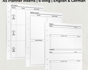 Puede incluir: Insertos de planificador A5 blancos con diseño de 6 anillas. Los insertos incluyen secciones para objetivos de vida, objetivos anuales y seguimiento de objetivos. El texto incluye "GOAL SETTING", "LIFE GOALS" y "GOALS".