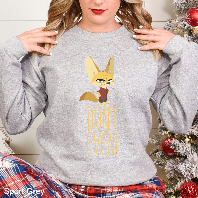 May include: Grey sweatshirt with a cartoon fennec fox wearing a red vest and a stern expression. The text "DON'T EVEN!" is printed in yellow. The sweatshirt is a casual style.