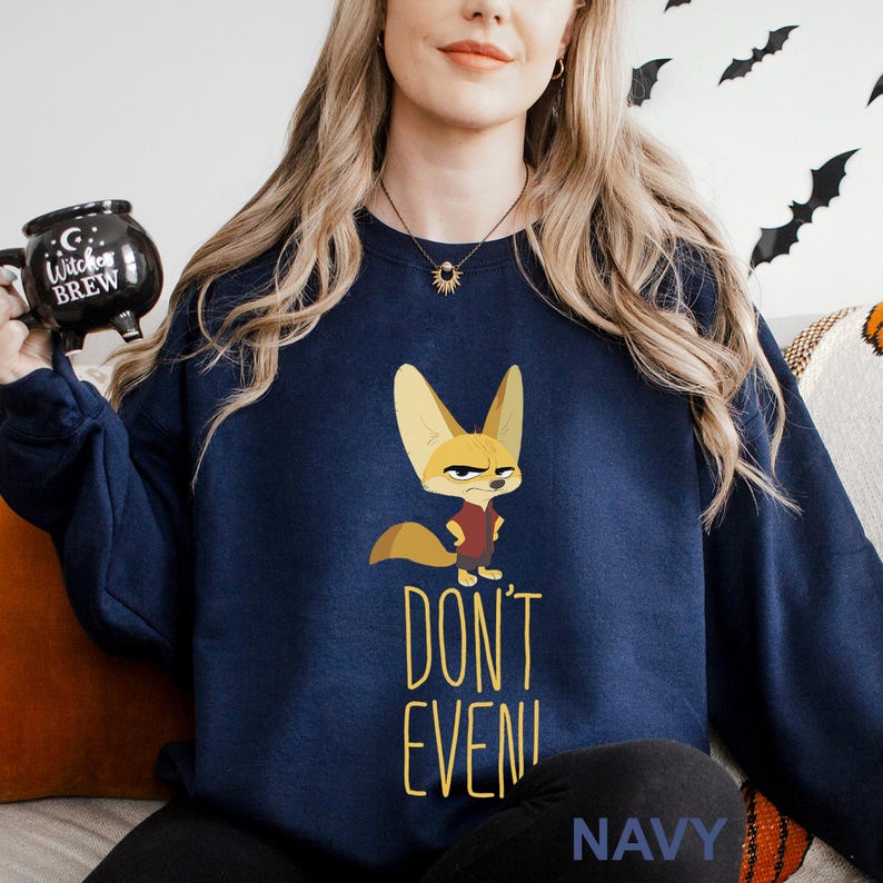 May include: Navy blue sweatshirt with a cartoon fox in a red vest and an angry expression. The words "DON'T EVEN!" are printed in yellow below the fox. The word "NAVY" is printed at the bottom of the sweatshirt.