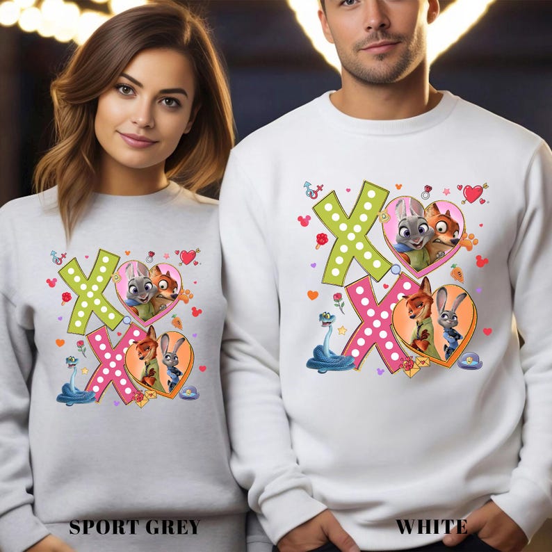 May include: Sport grey and white sweatshirts featuring a colorful graphic design. The design includes the letters "XO", hearts, and cartoon characters. The sweatshirts are a comfortable, casual style.