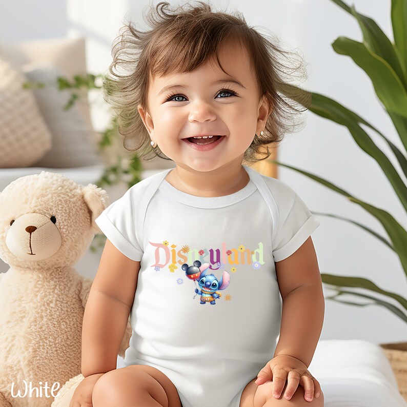 Puede incluir: Un body blanco para beb&eacute; con un gr&aacute;fico colorido de "Disneyland" que presenta a Stitch sosteniendo un globo de Mickey Mouse.