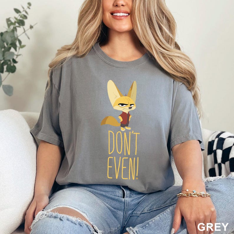 May include: Grey t-shirt featuring a cartoon fox with an angry expression. The fox is wearing a red shirt. Below the fox is the text "DON'T EVEN!" in yellow.