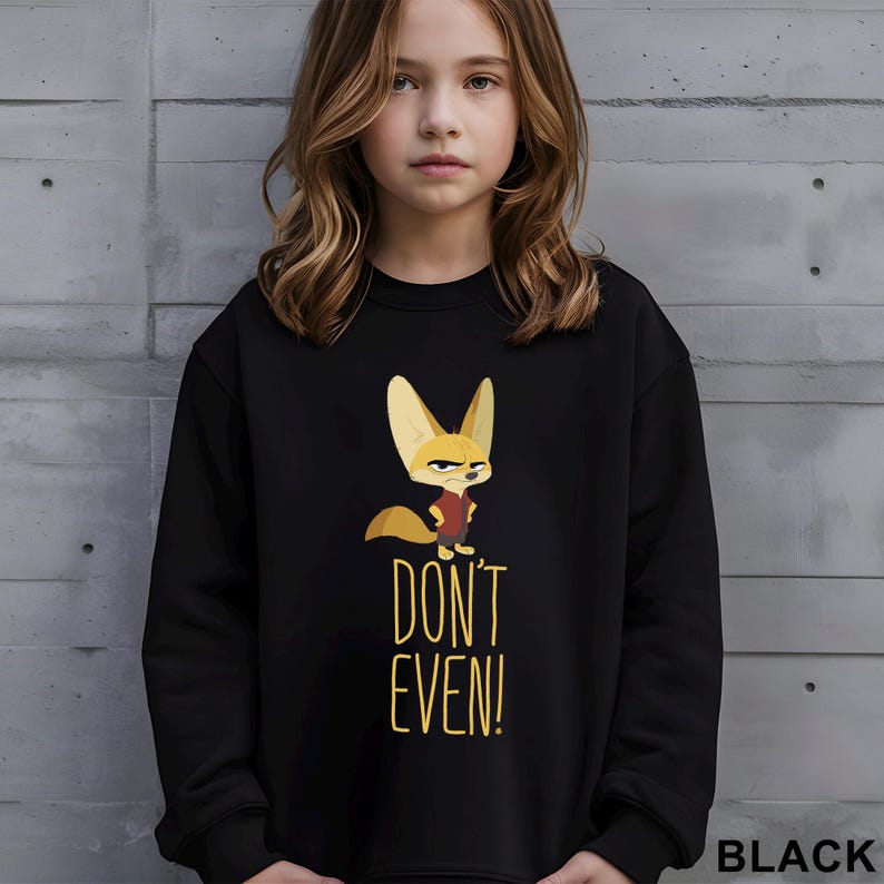 May include: Black sweatshirt with a cartoon fox and the words "DON'T EVEN!" in yellow. The fox wears a red shirt. The word "BLACK" is printed at the bottom right of the sweatshirt.