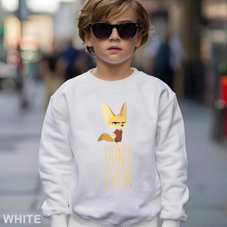 May include: White sweatshirt with a cartoon fox character and the text "DON'T EVEN!" in yellow. The fox wears a red vest. The sweatshirt is worn by a person wearing sunglasses.