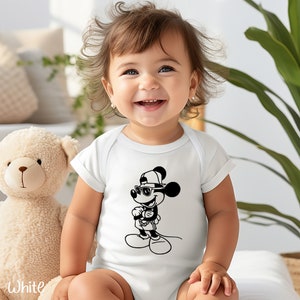 Może przedstawiać: Biały śpioszek dla niemowlęcia z czarno-białą ilustracją Myszki Miki w okularach przeciwsłonecznych i czapce z daszkiem.