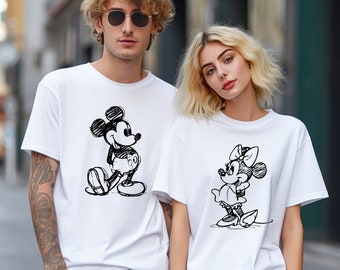 Könnte beinhalten: Zwei weiße T-Shirts mit einer schwarz-weißen Skizze von Mickey Mouse und Minnie Mouse. Das Wort "White" steht in der linken unteren Ecke des Bildes.