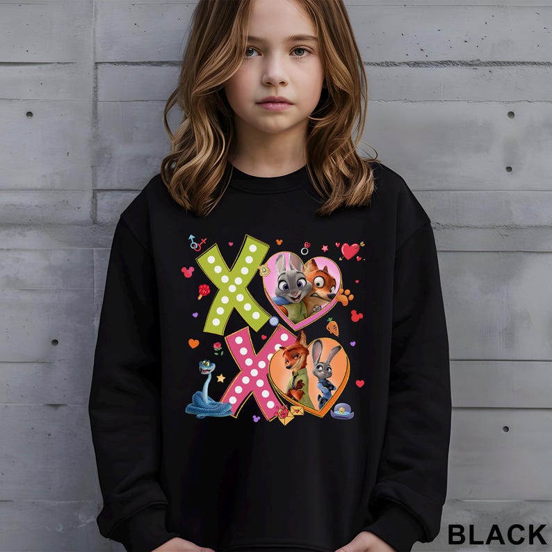 May include: Black sweatshirt featuring the characters from Zootopia. The design includes the letters "X" and "O" with heart-shaped graphics and cartoon characters. The word "BLACK" is printed at the bottom right.