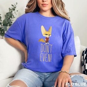 May include: A blue t-shirt with a cartoon fox graphic and the text "DON'T EVEN!". The fox is wearing a red vest. The shirt is a solid blue color.