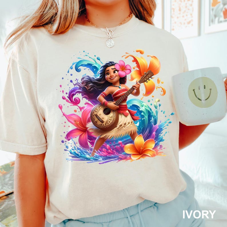 Puede incluir: Camiseta de color marfil con una ilustraci&oacute;n vibrante de un personaje de dibujos animados tocando un ukelele, rodeado de flores coloridas y salpicaduras de agua. Cerca se sostiene una taza blanca con una carita sonriente. La palabra "IVORY" est&aacute; impresa en la parte inferior.