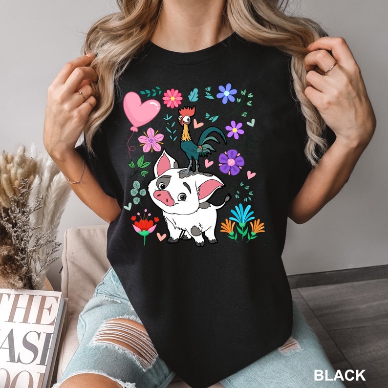 K&ouml;nnte beinhalten: Schwarzes T-Shirt mit einem Cartoon-Schwein und einem Hahn mit Blumen und einem Herzen. Der Text "BLACK" befindet sich in der rechten unteren Ecke des Bildes.