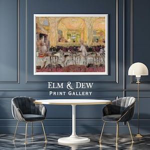 May include: A framed print of an impressionist painting depicting a restaurant interior with patrons and servers. The print is displayed above a white table and two gray velvet chairs with gold legs. The text "ELM & DEW PRINT GALLERY" is below the print.