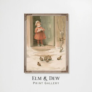May include: Framed vintage print featuring a young person in a red dress and white bonnet standing in a snowy doorway, feeding birds. The print has a warm, nostalgic feel, with the text "ELM & DEW PRINT GALLERY" at the bottom.
